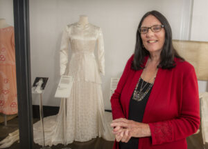 Judith Clarke from Cumwhitton with her mother Julie Martin's wedding dress from 1948 in an exhibition at Tullie House in Carlisle. Photograph Jonathan Becker beckerphoto.co.uk