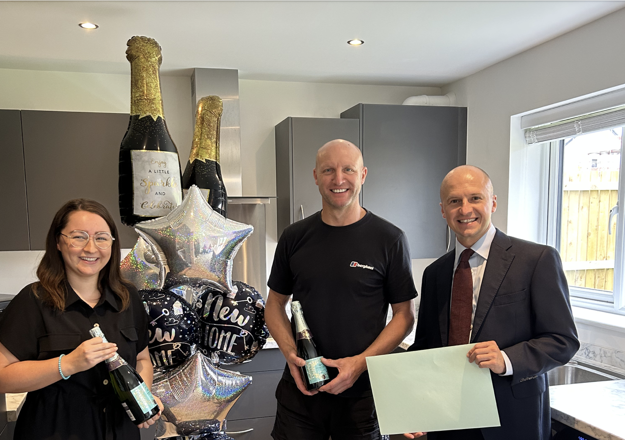 Kev Walker (centre) is welcomed as the 500th customer of Genesis Homes by Sales Executive Ashley Conlan and Managing Director Nicky Gordon.