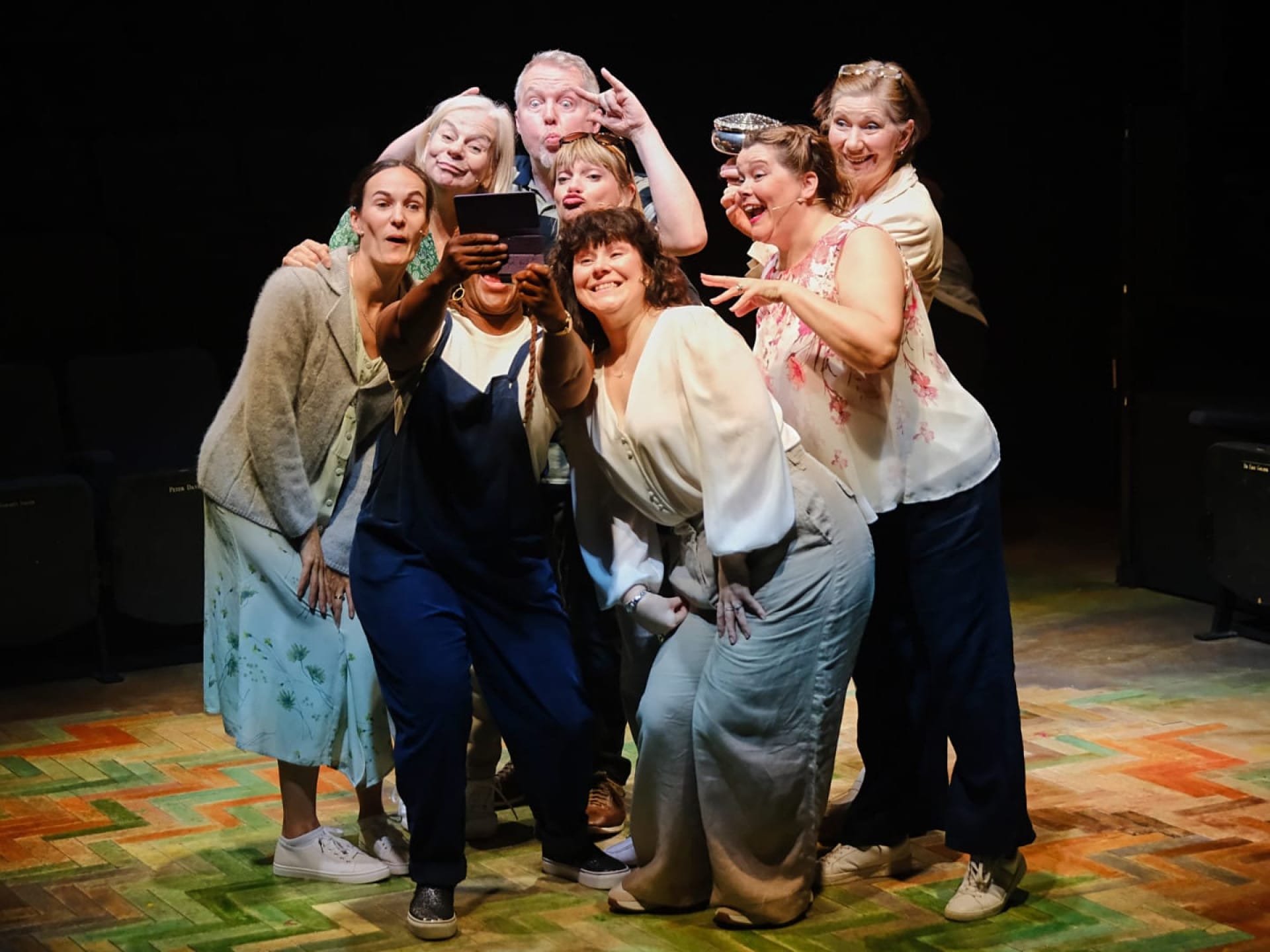 Women and one man posing for a photo, laughing